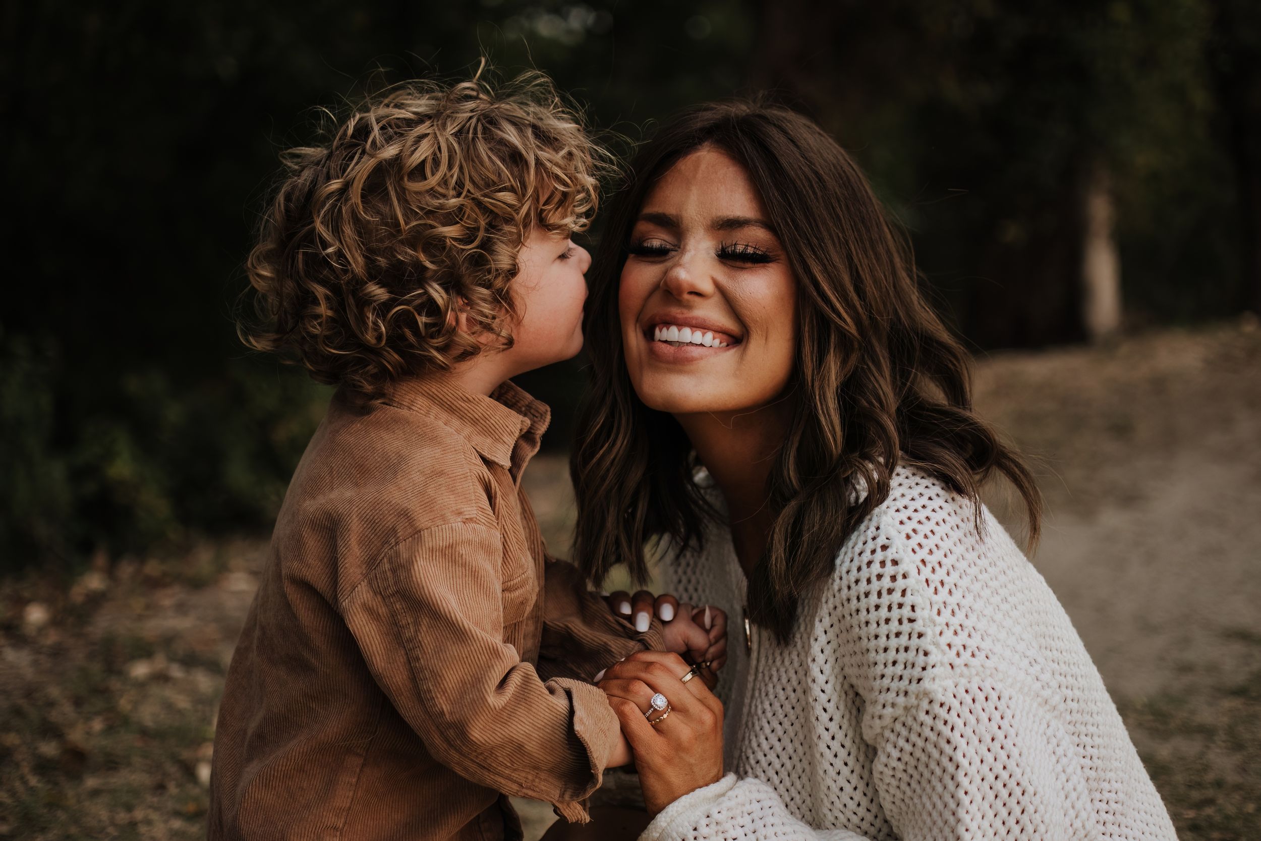 Genuine laughter and joy shared between two people during an outdoor photoshoot.