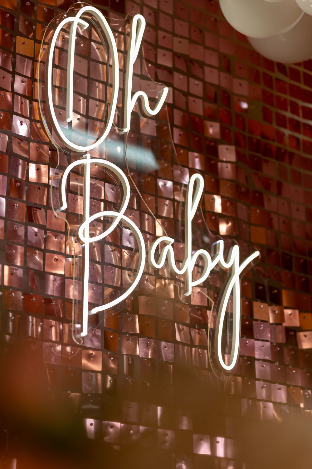 Glowing white neon cursive text sign against a rustic brick wall creates a warm, ambient atmosphere.