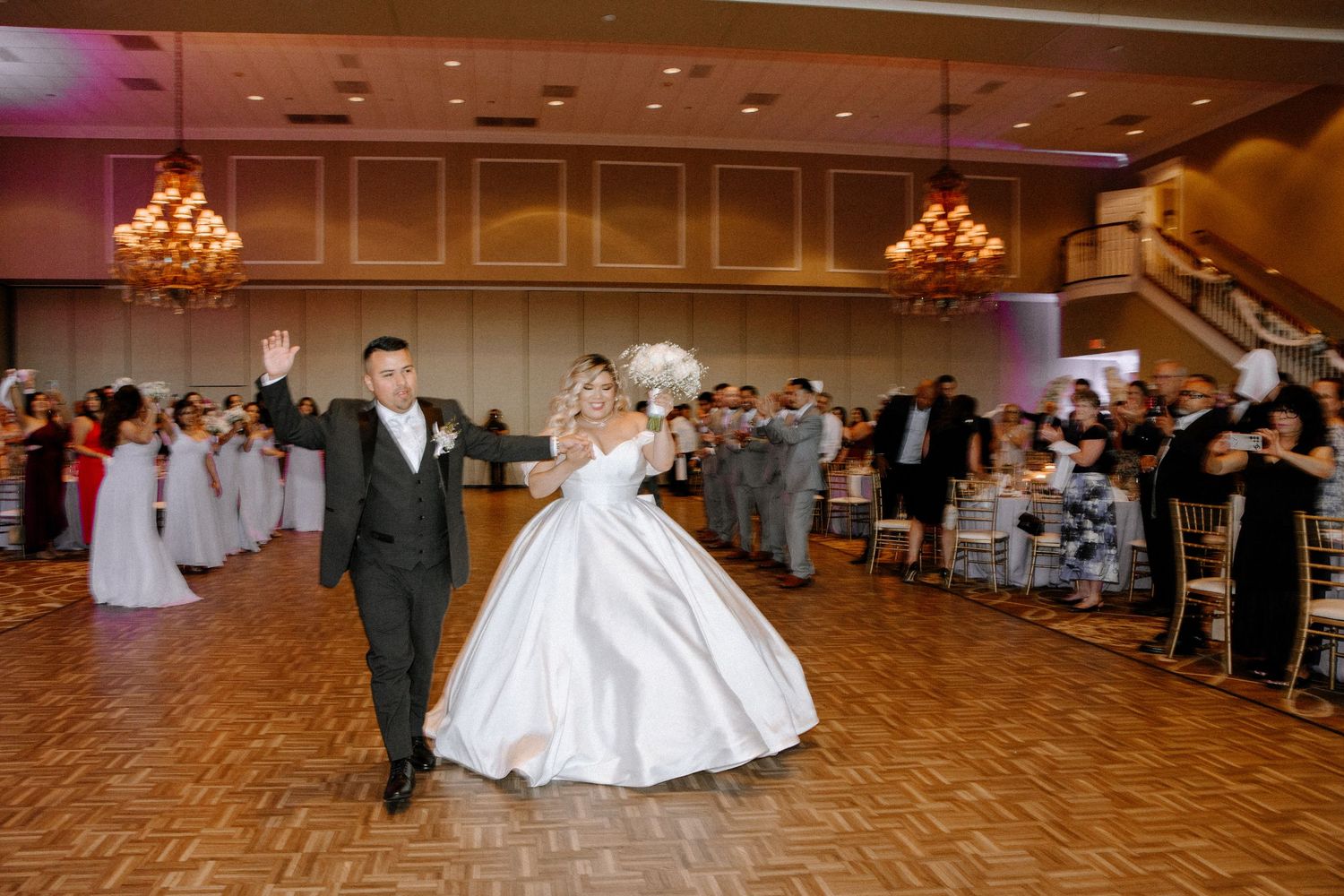 Panoramic sequence of a wedding couple dancing playfully on a parquet dance floor at their reception celebration.