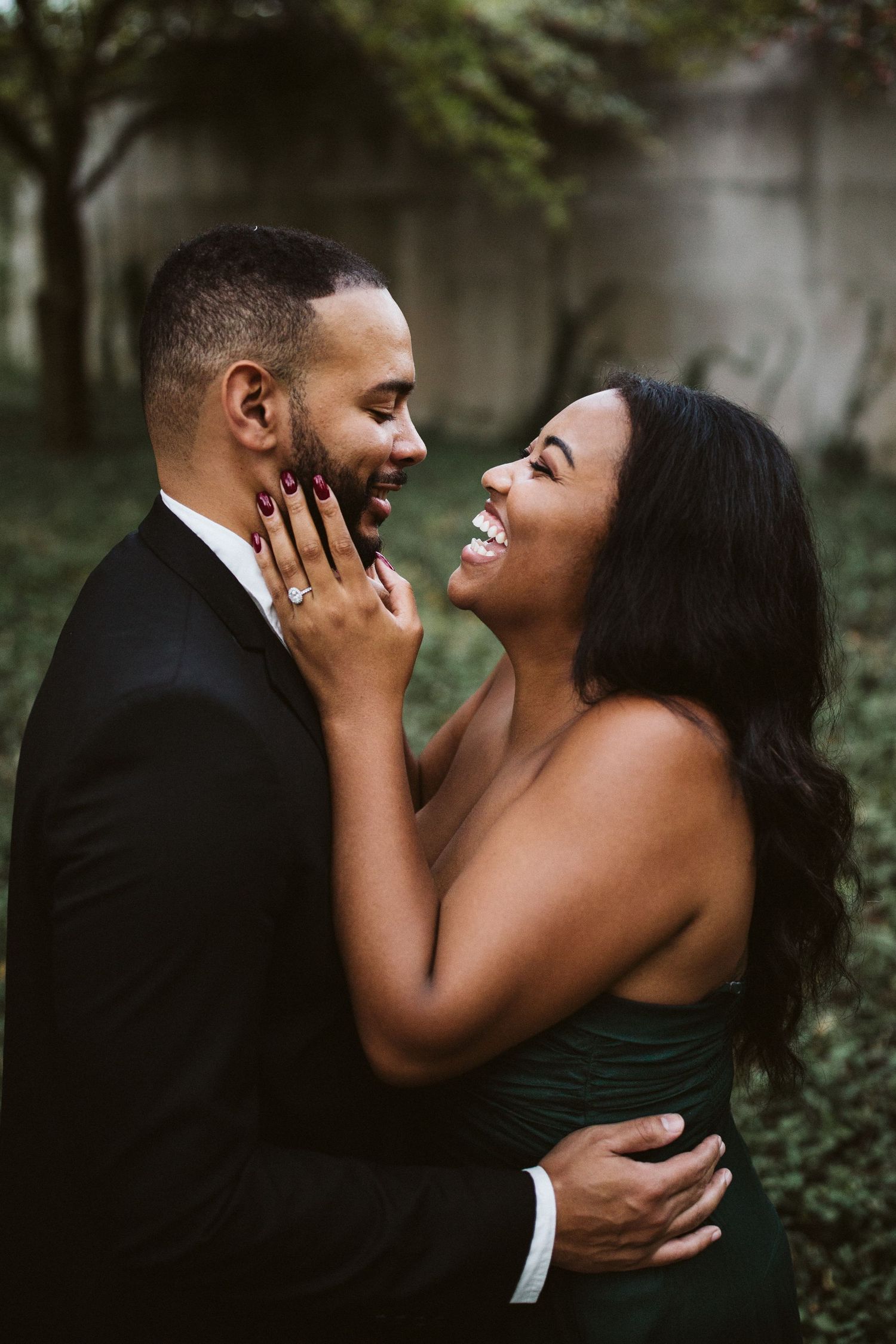 An intimate moment of laughter and joy shared between two people in formal attire.