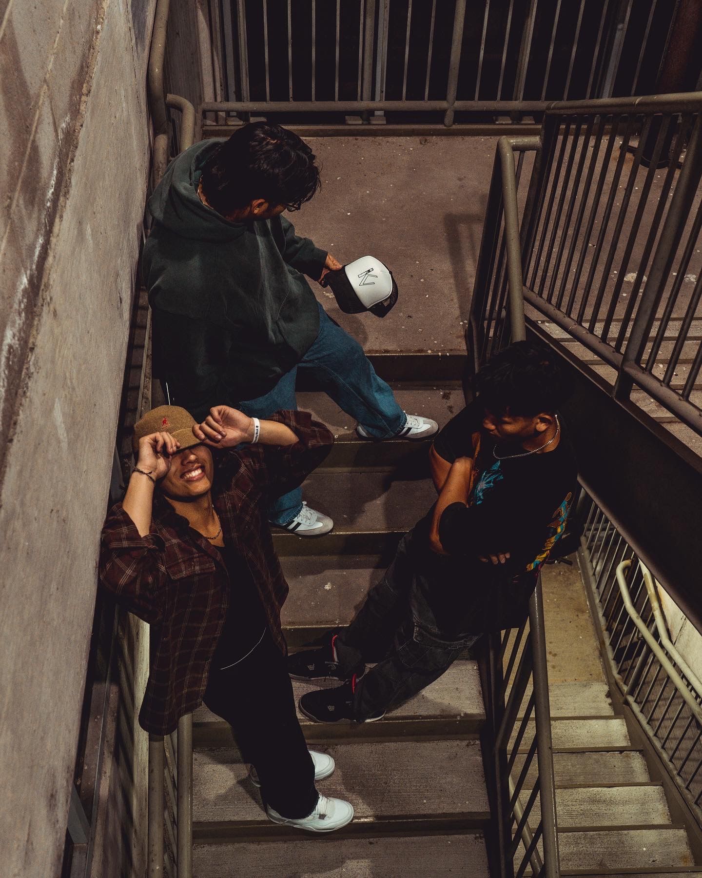 Someone sitting on concrete stairs in urban setting at night.