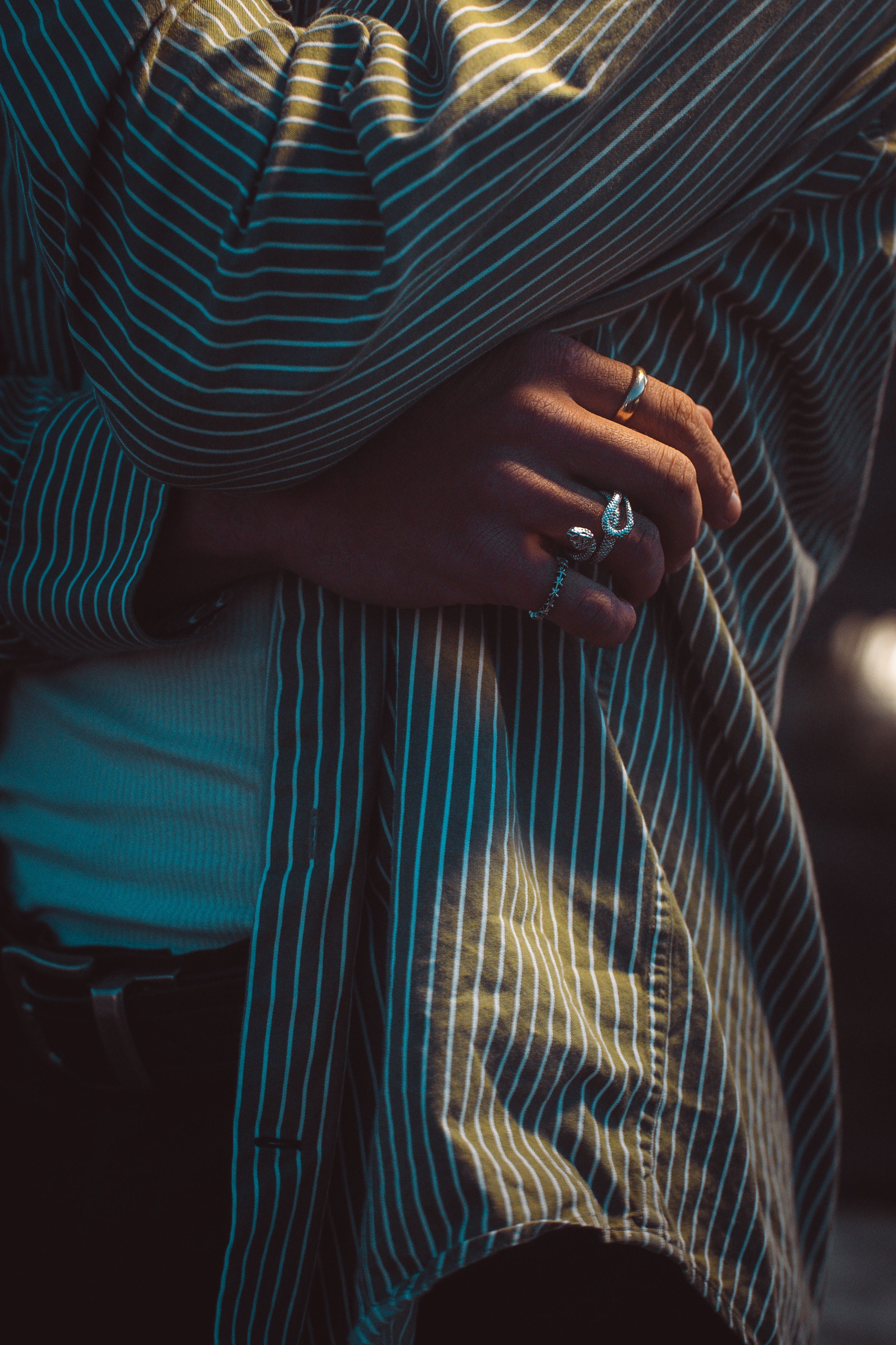 Silhouetted hands against dark background with glowing blue neon lines creating geometric patterns and contrast.