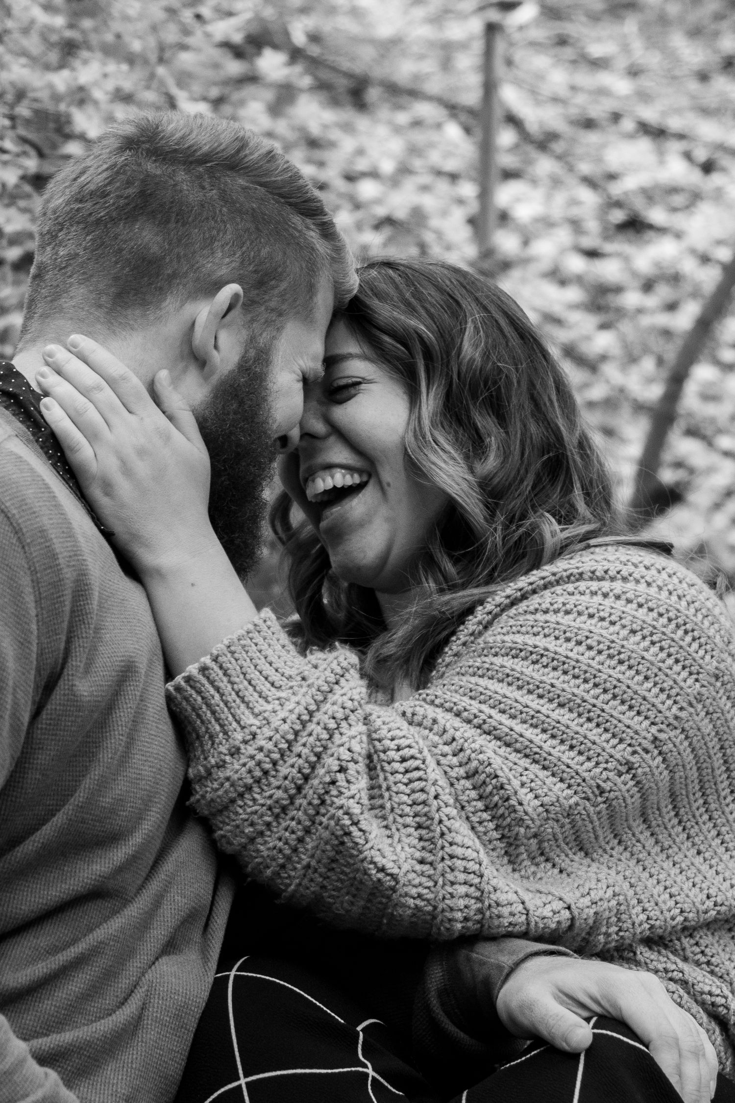 Couple laugh together in an Utah forest.
