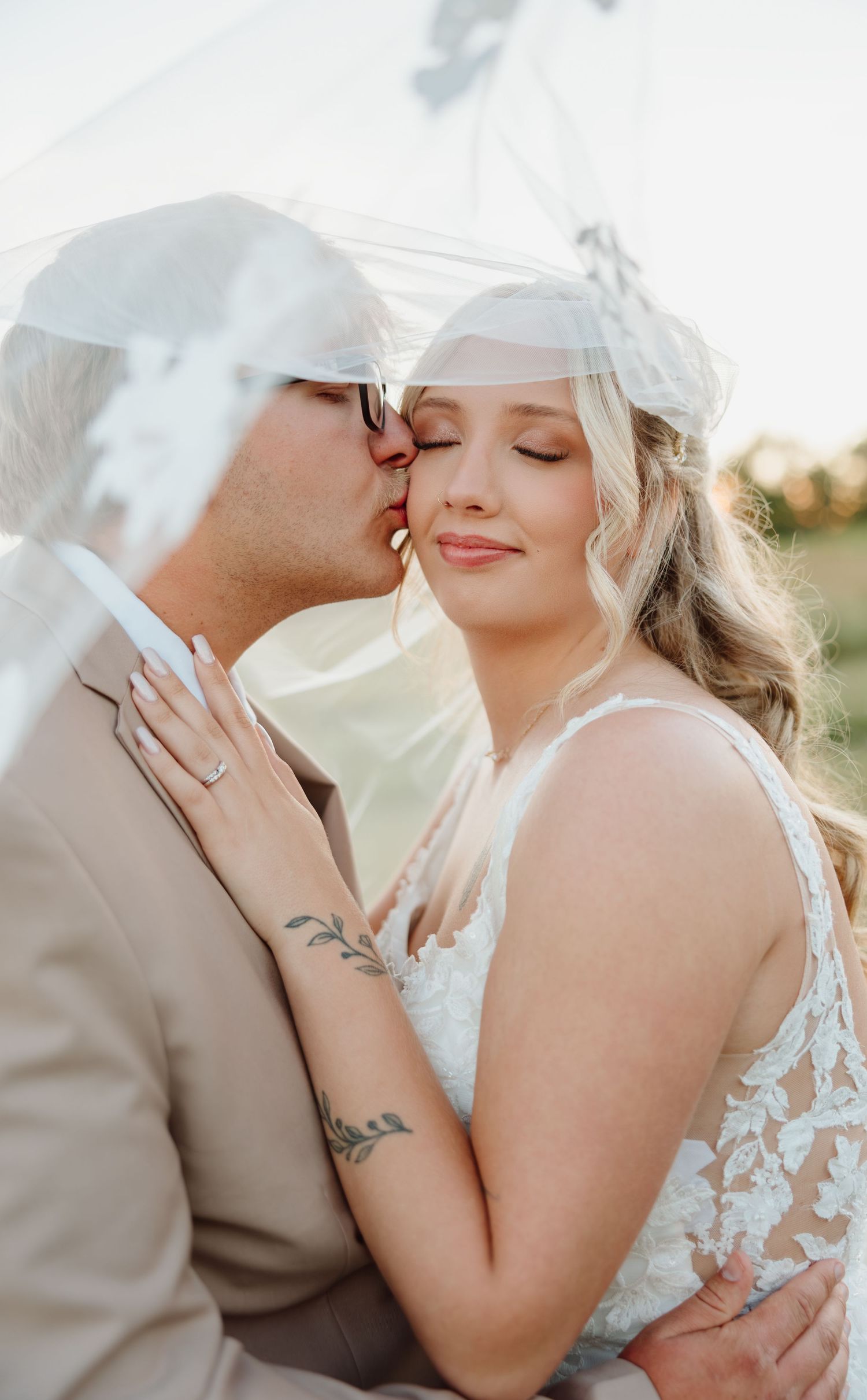 Outdoor autumn wedding ceremony with couple sharing romantic moment in blue suit and white dress.