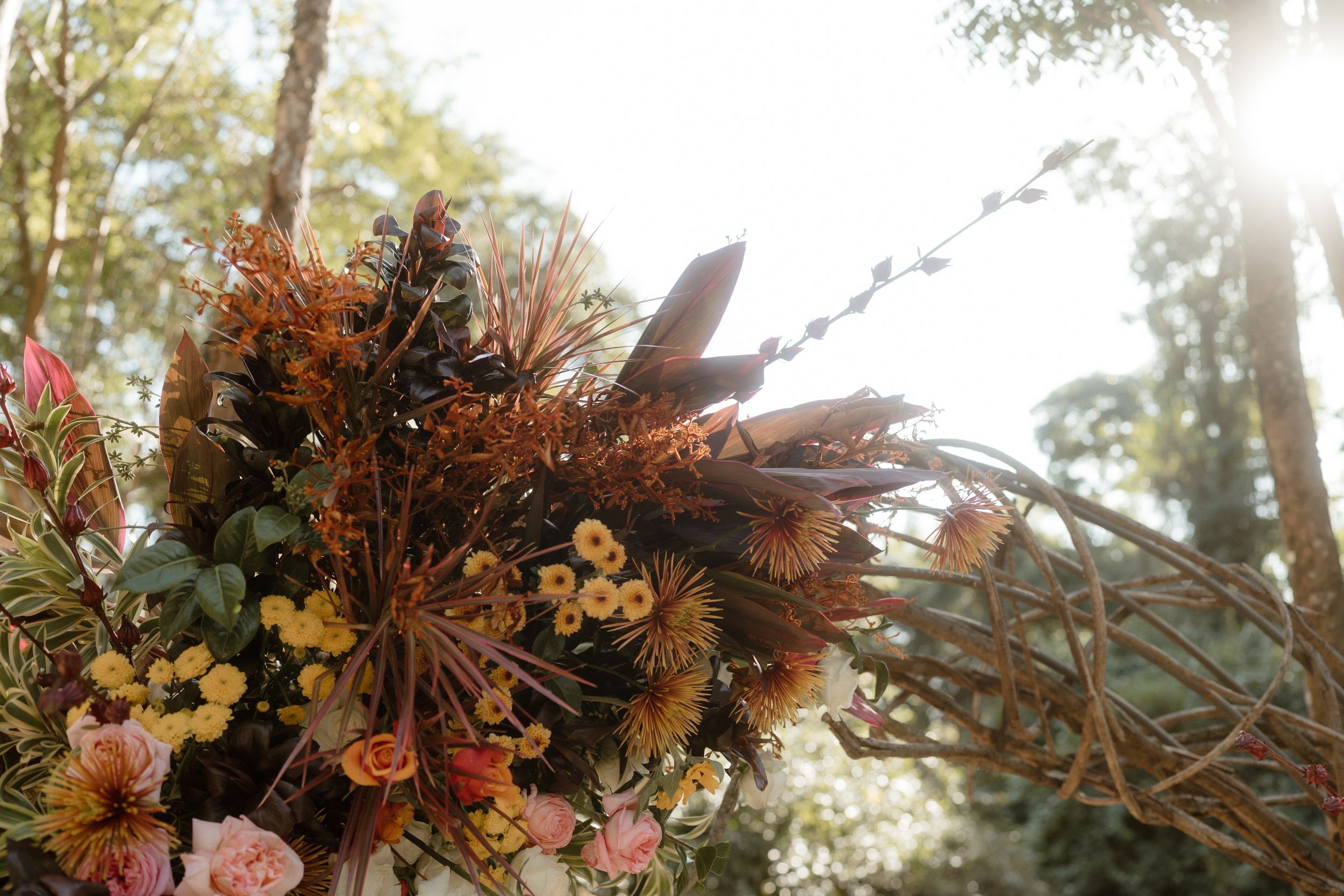 Close-up of autumn-colored dried floral arrangement with pink and orange blooms.