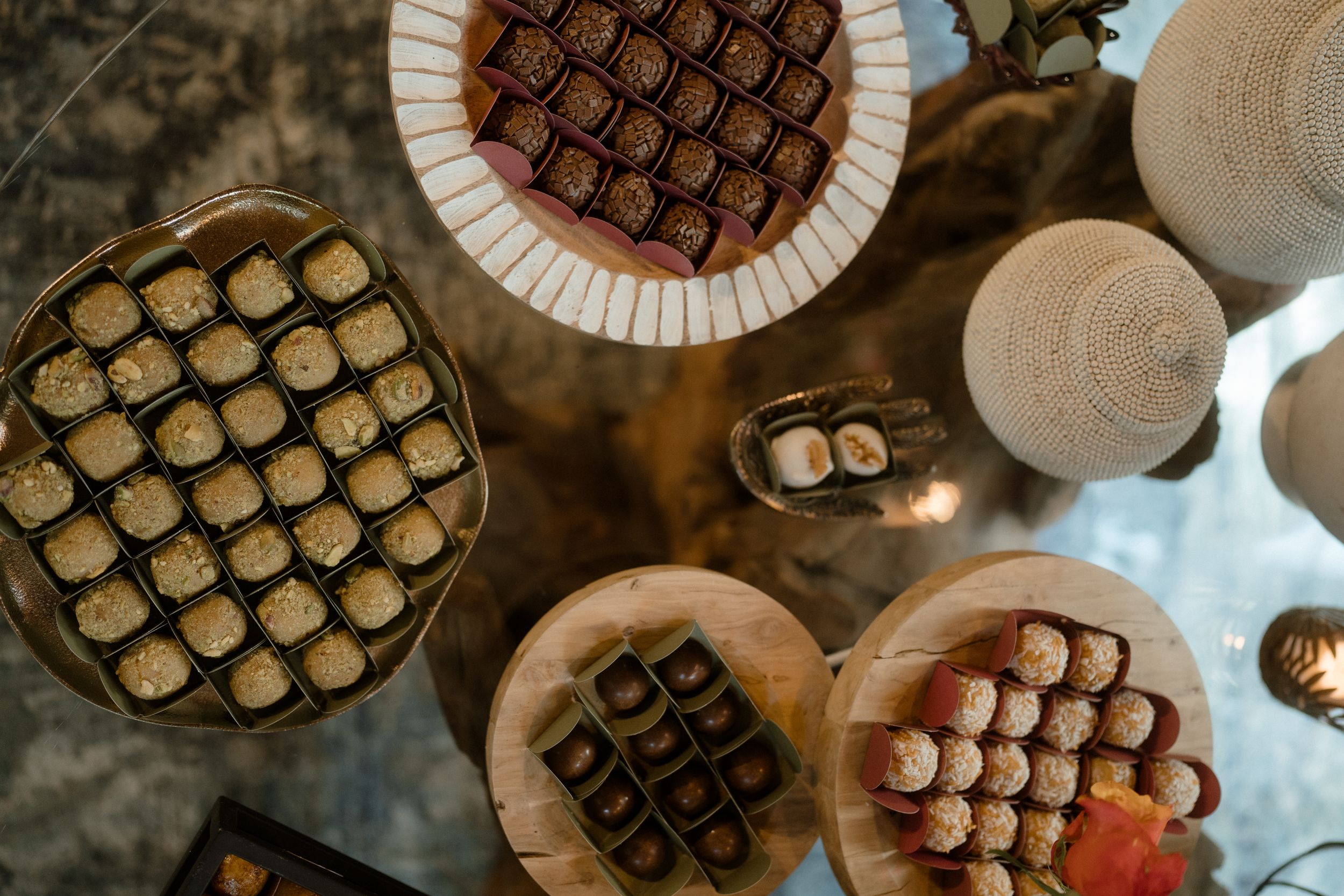 Overhead view of artfully arranged chocolate truffles and desserts on a rustic wooden display.