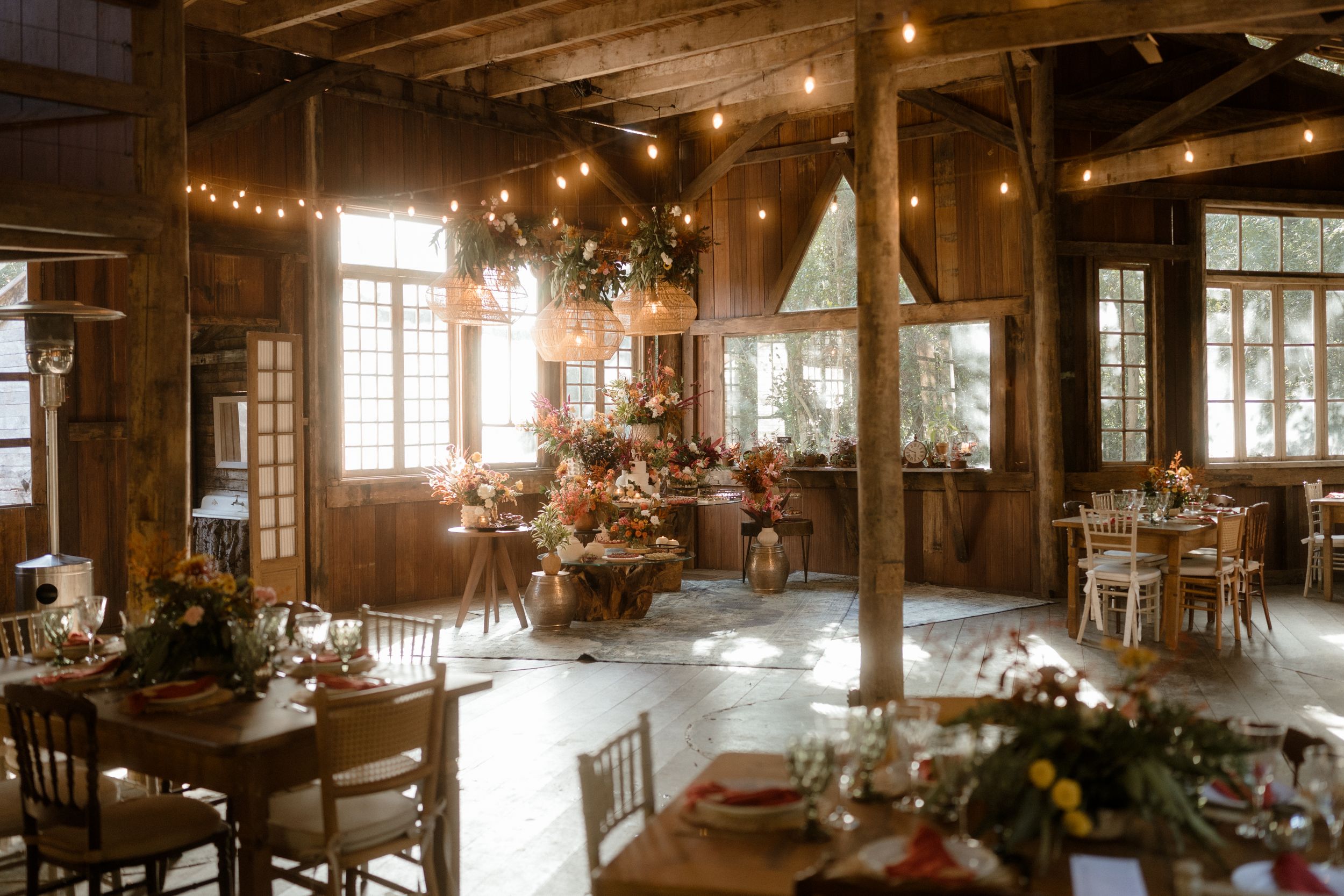 Rustic wooden event space with string lights creating a warm, romantic atmosphere.