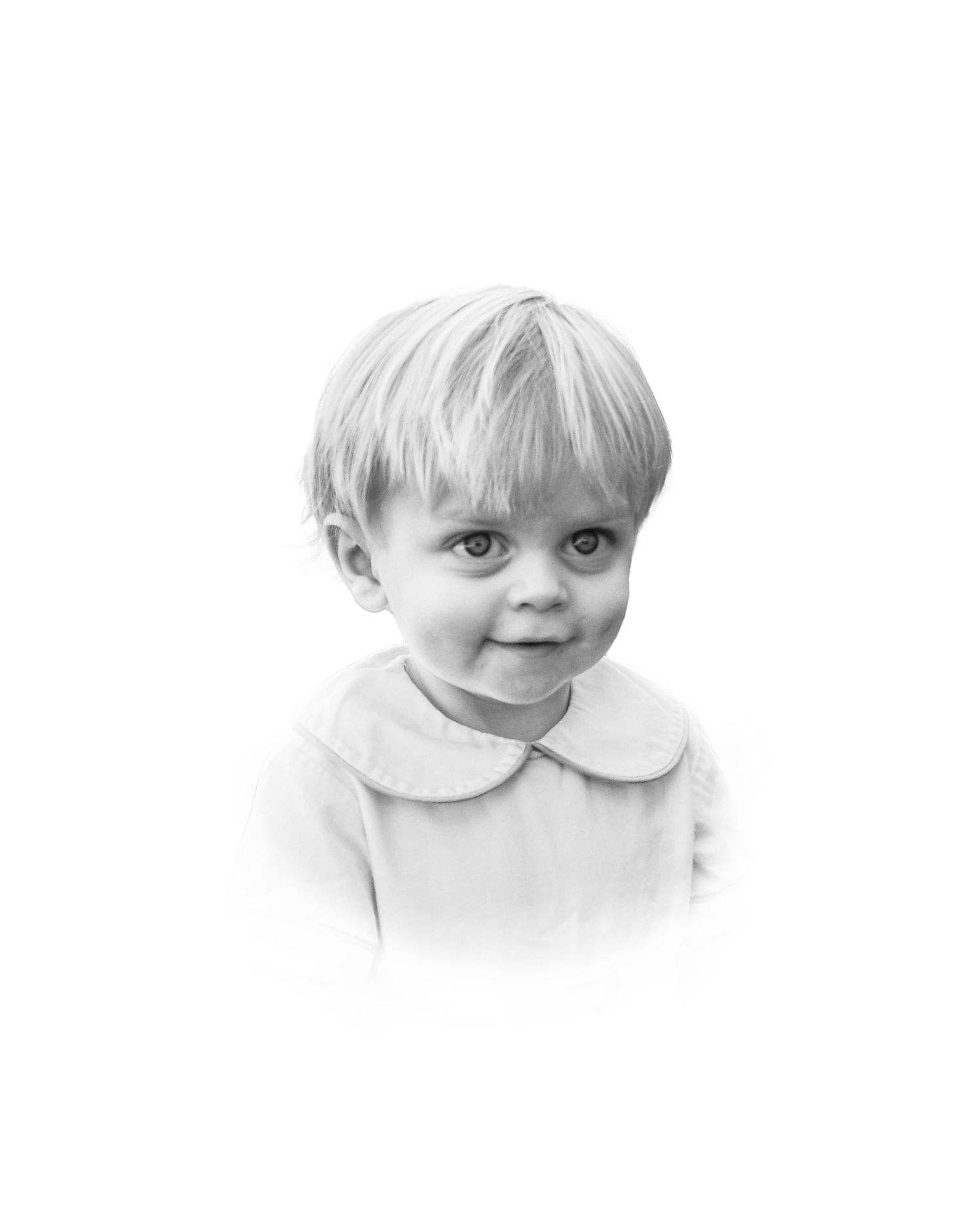 Black and white portrait of toddler wearing white collared shirt.
