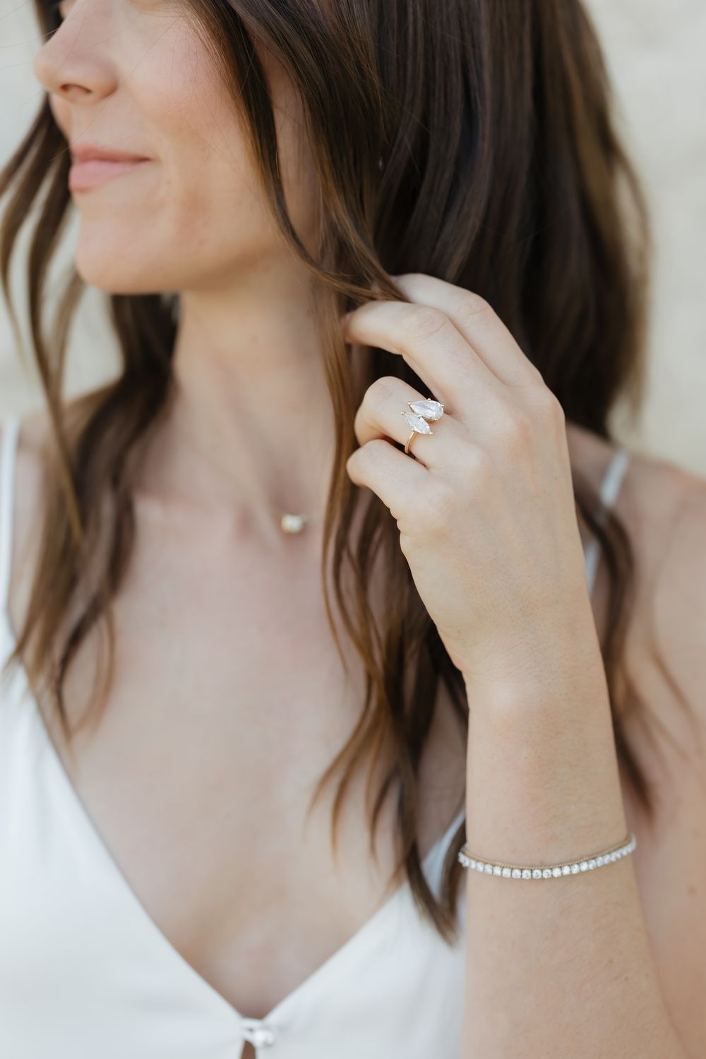 Close-up shot of elegant bridal jewelry including a diamond ring and pearl bracelet.