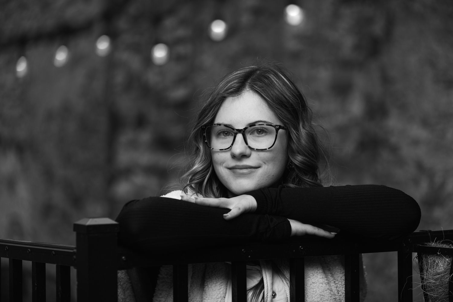 A black and white portrait series shows a person in glasses posing against a dark background with dramatic lighting.