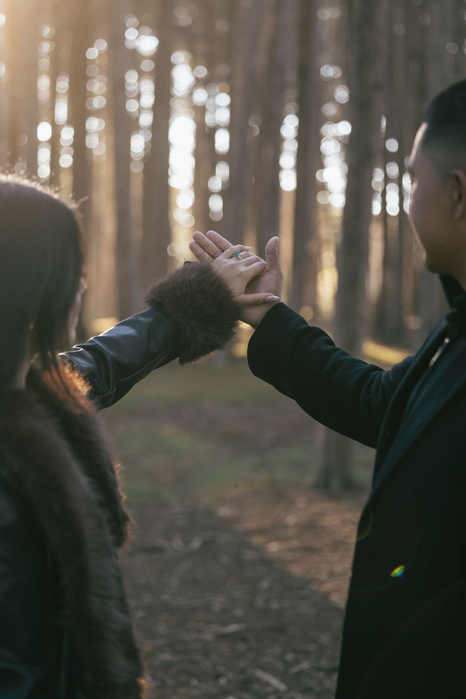Couple embracing on foggy beach wearing casual denim and jackets.