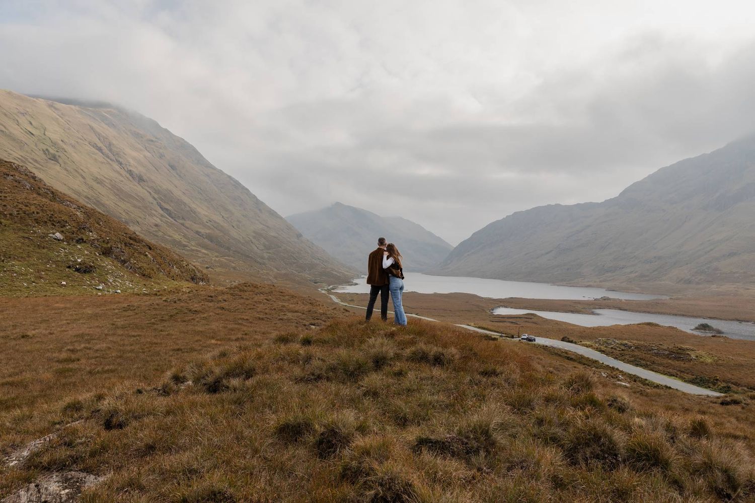 couple hugging with Doolough valley in the background during their adventure engagement session