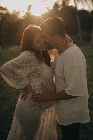 Couple sharing tender moment at sunset in garden setting.