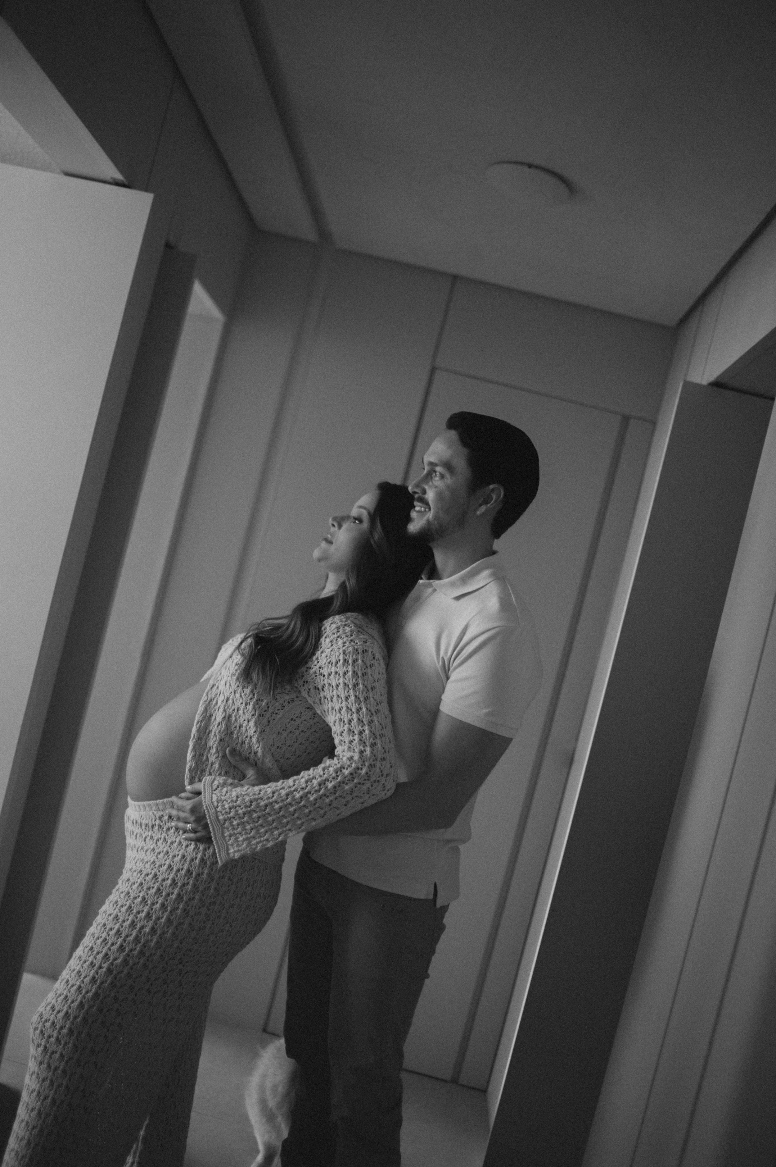 A series of black and white photos showing a couple in an intimate dance pose in a hallway.