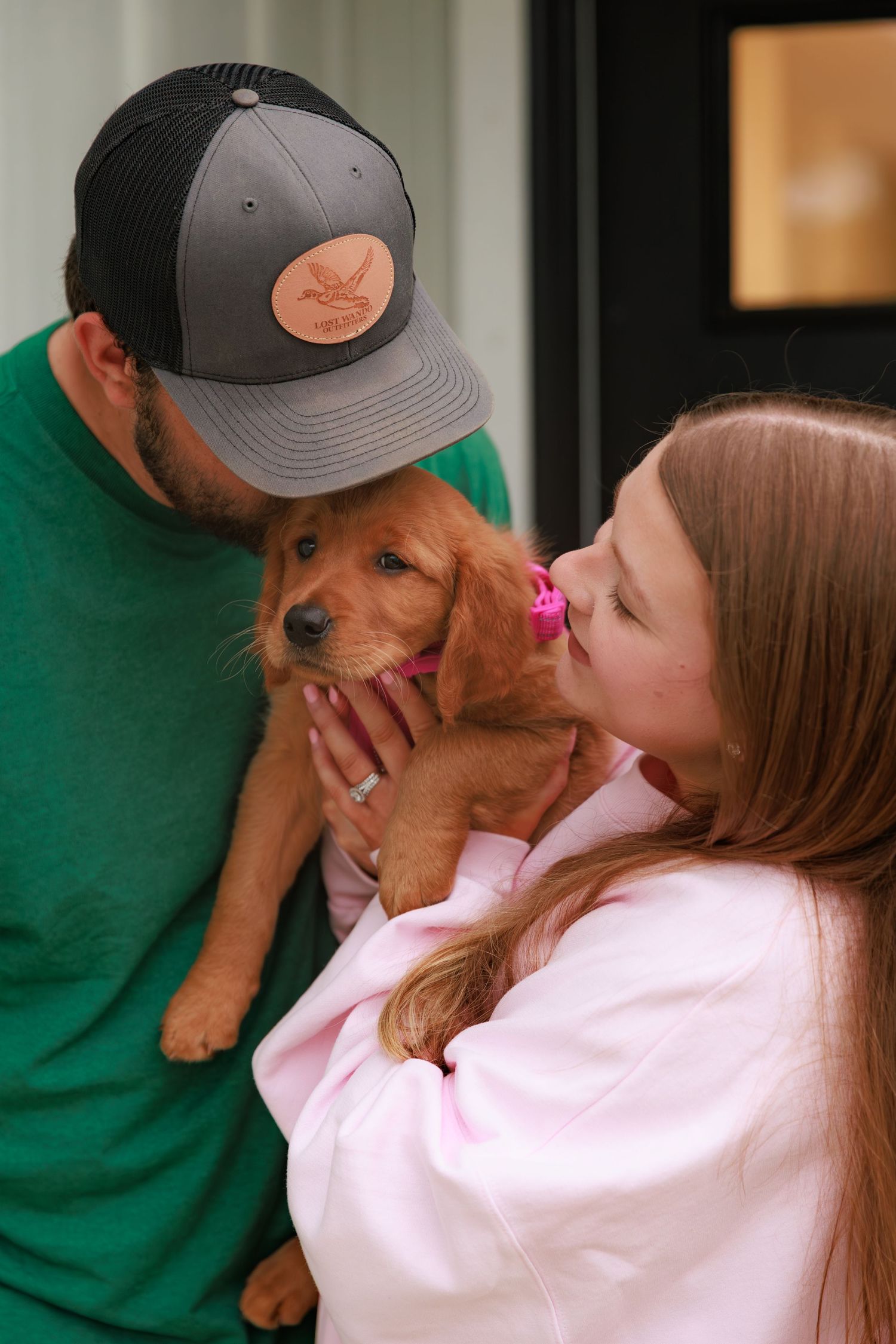 A woman in a pink sweater gives loving kisses to an adorable golden retriever puppy in a series of sweet photos.