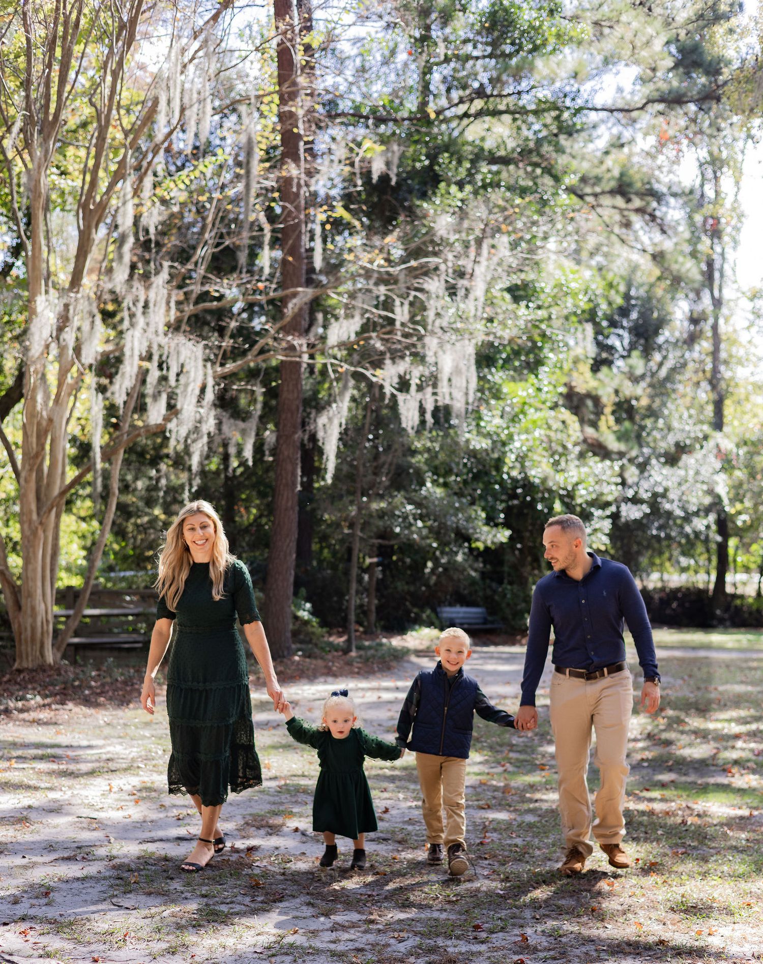 A series of candid family photos taken outdoors among tall trees and Spanish moss in a natural park setting.