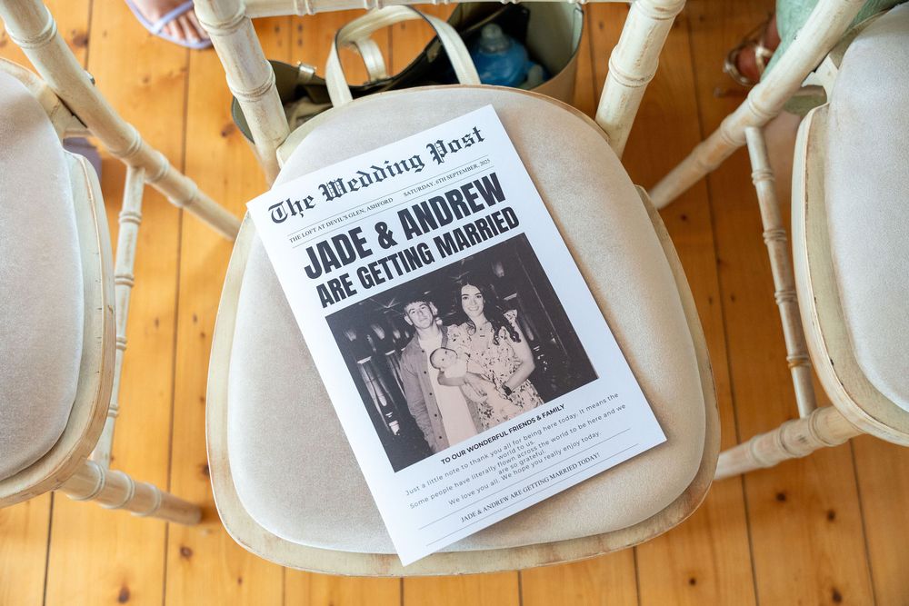 Black and white wedding announcement clippings displayed in heart-shaped dishes against a warm wooden background.