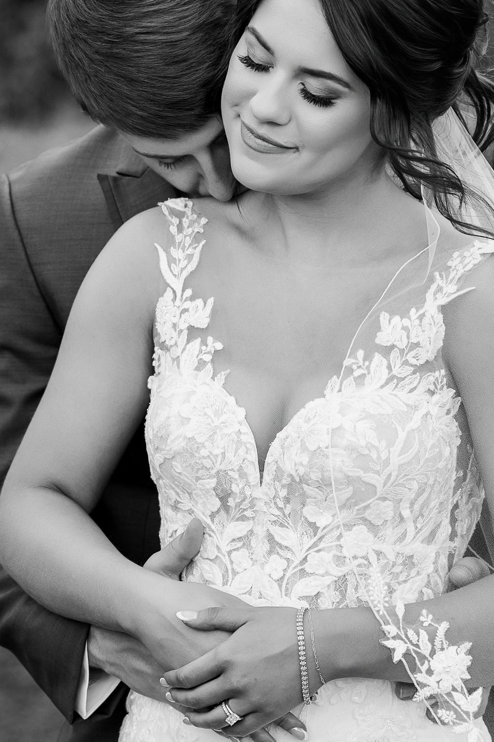 Black and white intimate portrait showcasing intricate lace wedding dress details.