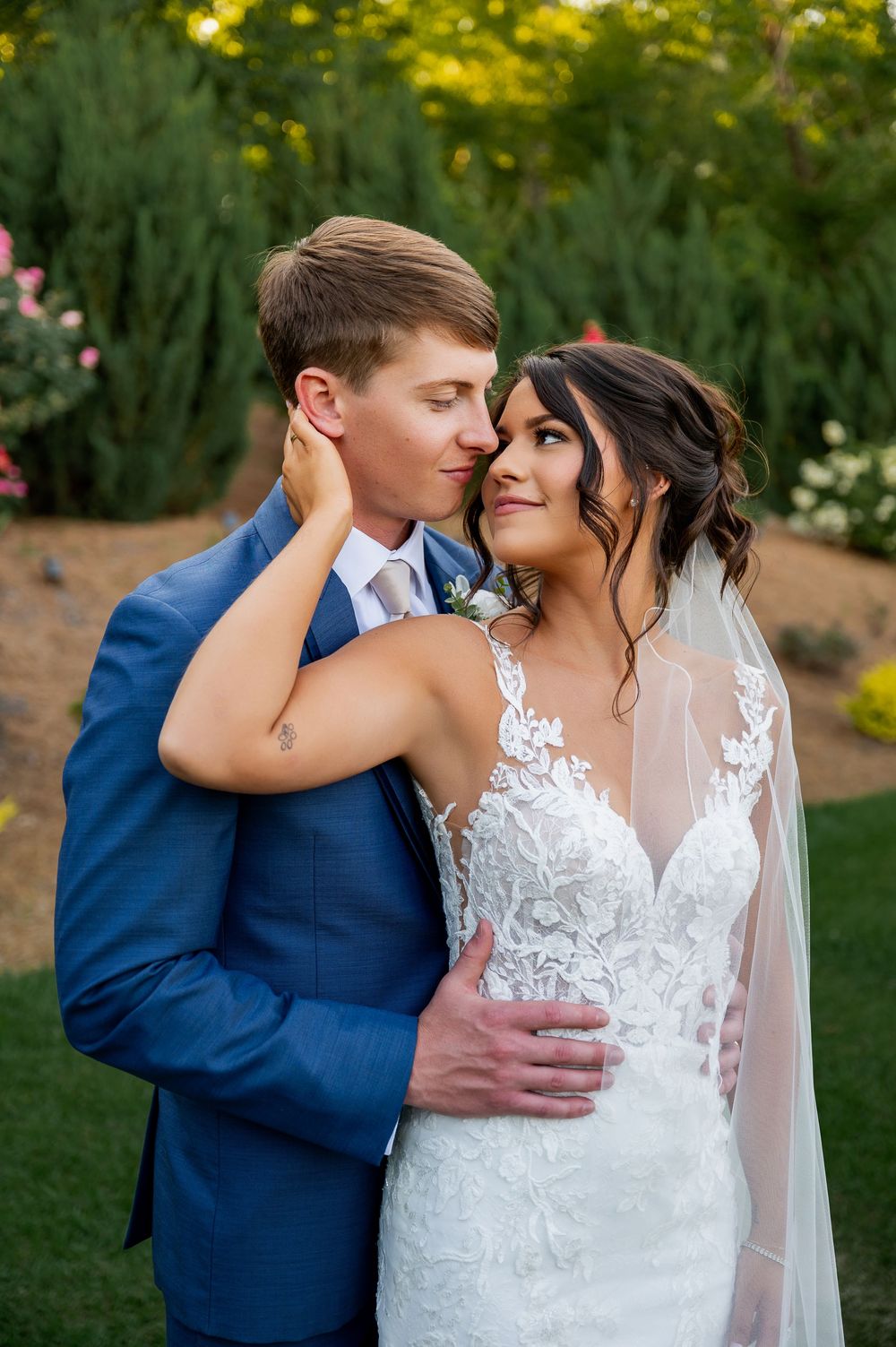 A romantic wedding photo sequence showing a couple in a navy suit and white lace dress embracing in a garden setting.