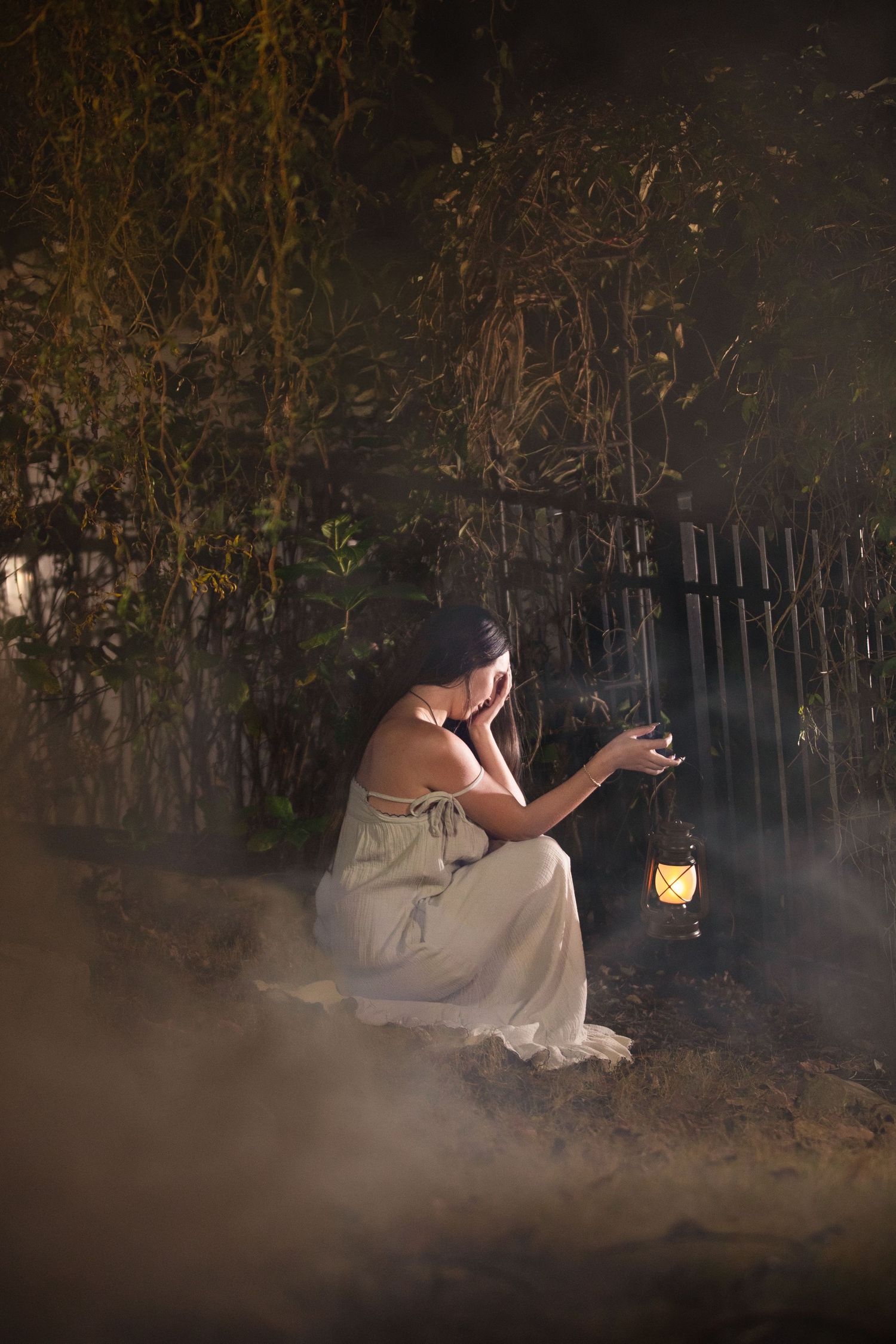A dreamy outdoor photoshoot with fog effects creating an ethereal atmosphere in a wooded setting.