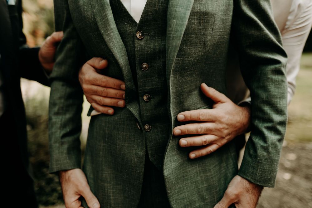 Elegant formal attire details showing dark suit jackets and formal wear.