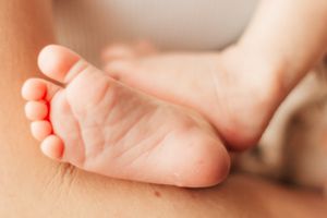 Close-up photo of tiny baby feet with soft natural lighting on a white background. | Motherhood + Family Photographer Westminster, CO