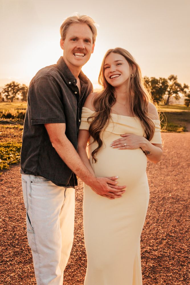 A couple shares a joyful moment during their maternity photoshoot. | Motherhood + Family Photographer Westminster, CO