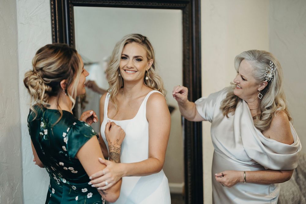 Emotional moments shared during wedding preparations in bright indoor setting.