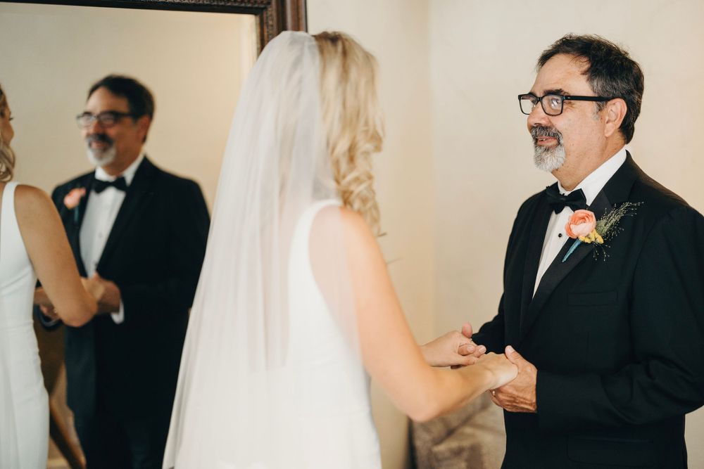 A tender first look moment between wedding couple in formal attire.