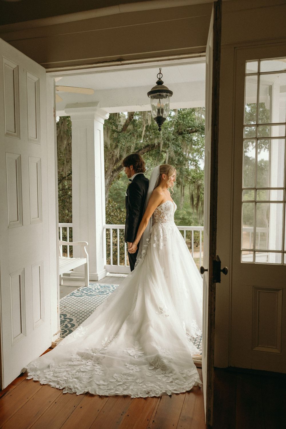 A stunning wedding dress with a long lace train is displayed at The Elms of Coosada in Coosada, Alabama