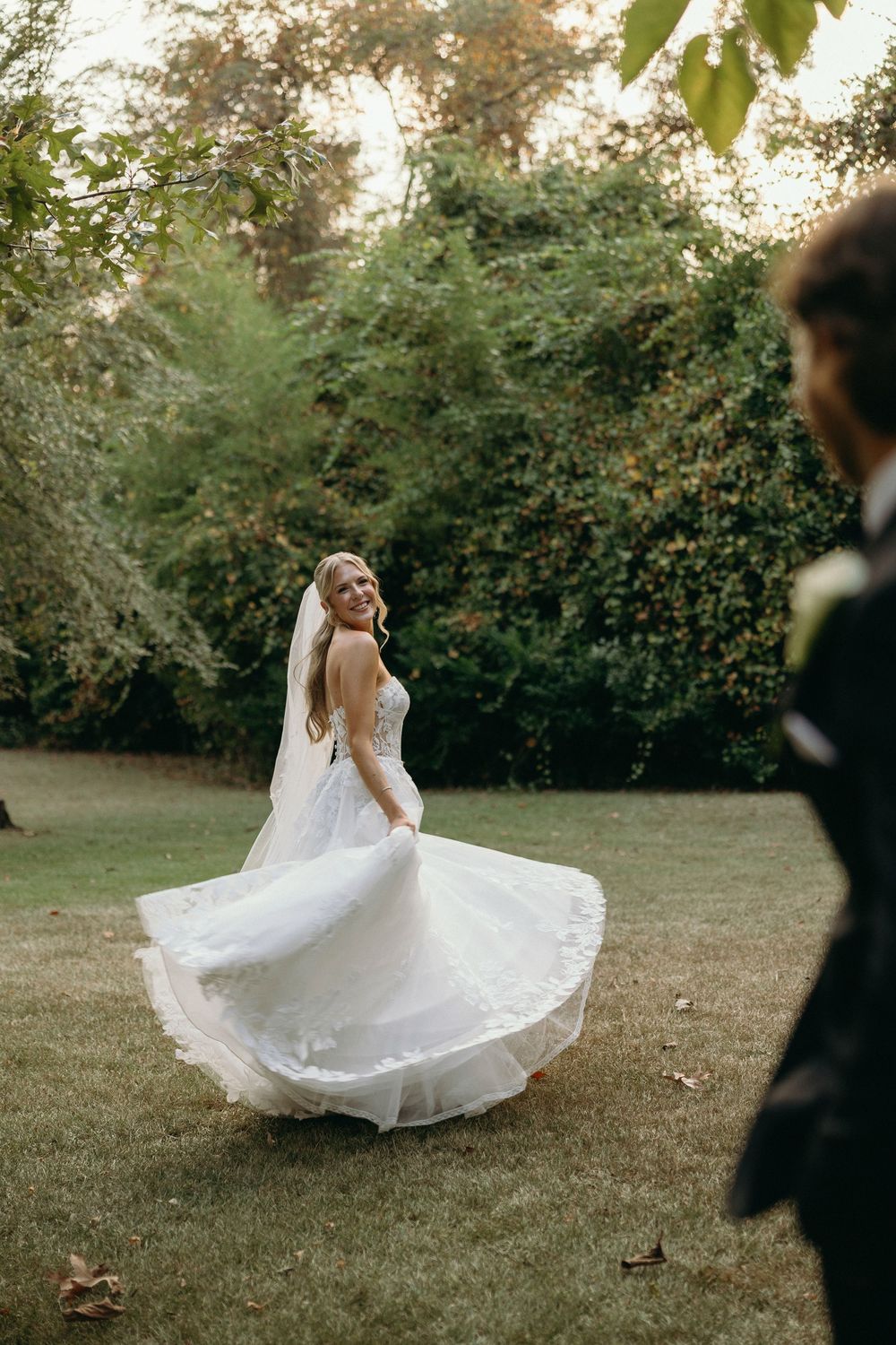 A bride spins gracefully in a flowing white wedding gown on a lawn at The Elms of Coosada in Coosada, Alabama