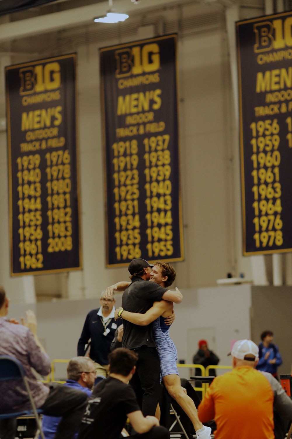 Championship banners hang from the rafters of a basketball gymnasium during an event.