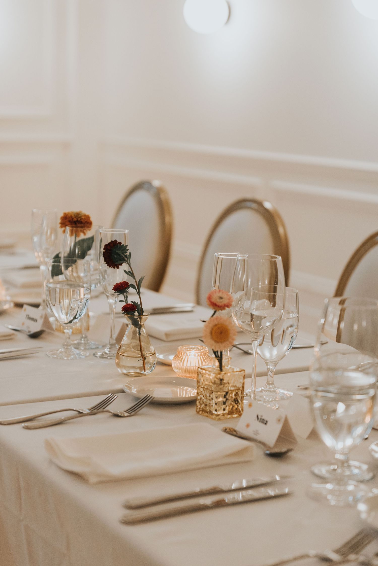 Elegant table settings with white linens, glassware, and candlelight create an intimate dining atmosphere.