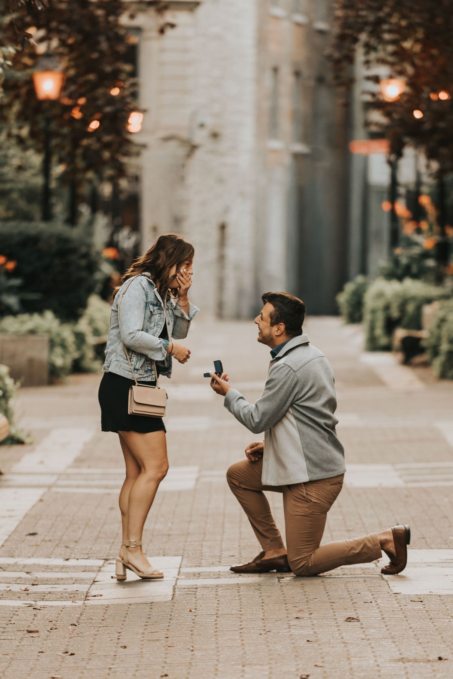 A romantic marriage proposal sequence showing a couple on a brick walkway surrounded by columns and warm lighting.