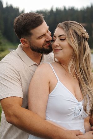 Intimate couple embraces in romantic close-up shots against forest backdrop.