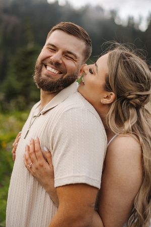 Joyful couple sharing laughter and embraces in an outdoor setting.