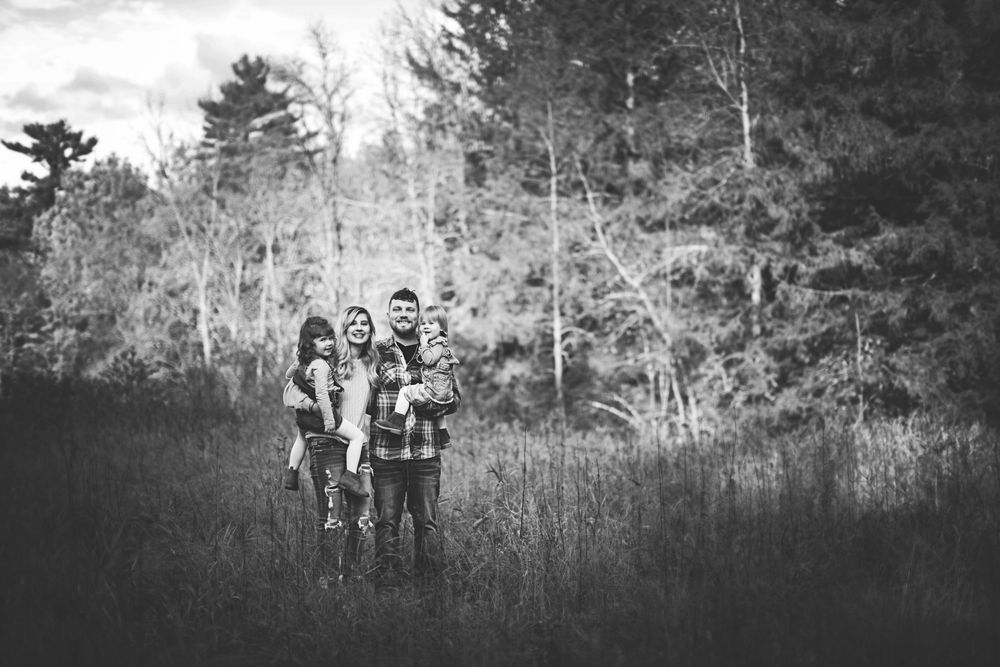 Black and white photo of people walking through a wooded area.