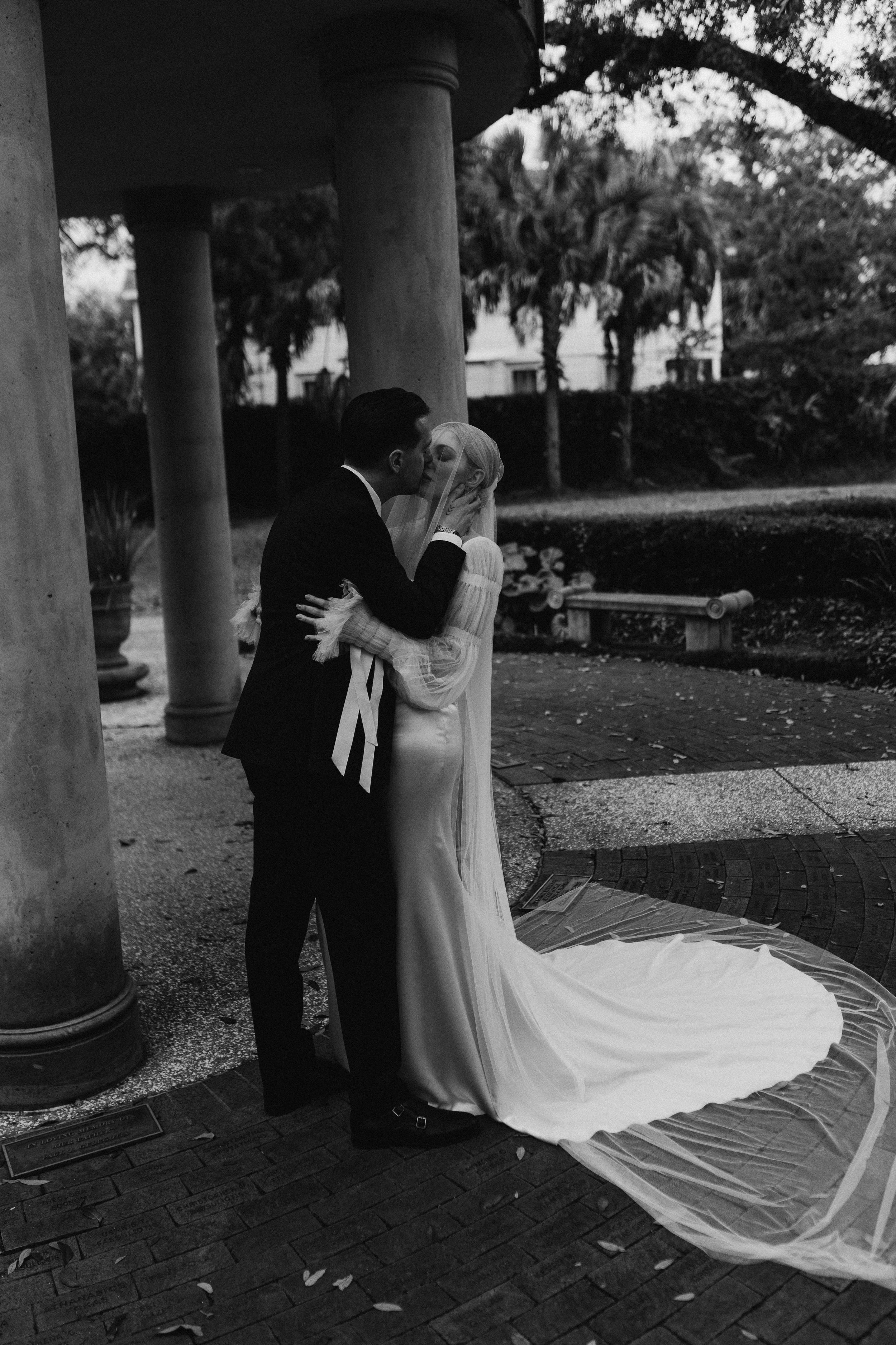 A romantic black and white wedding photo sequence showing a couple dancing under stone pillars with a flowing dress train.