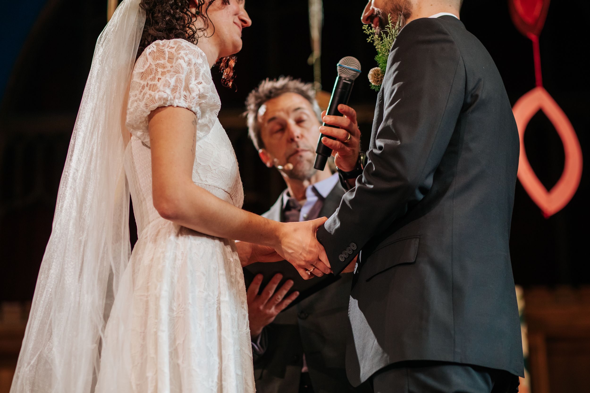 A couple shares their first dance at their wedding reception while guests look on in a dimly lit venue.