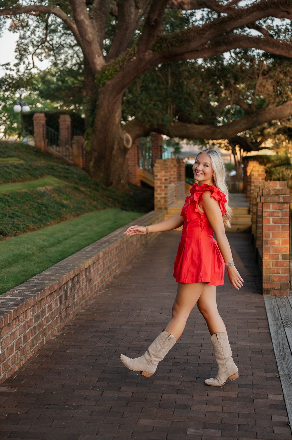 Casual outdoor photoshoot on brick walkway with tall trees and natural lighting.