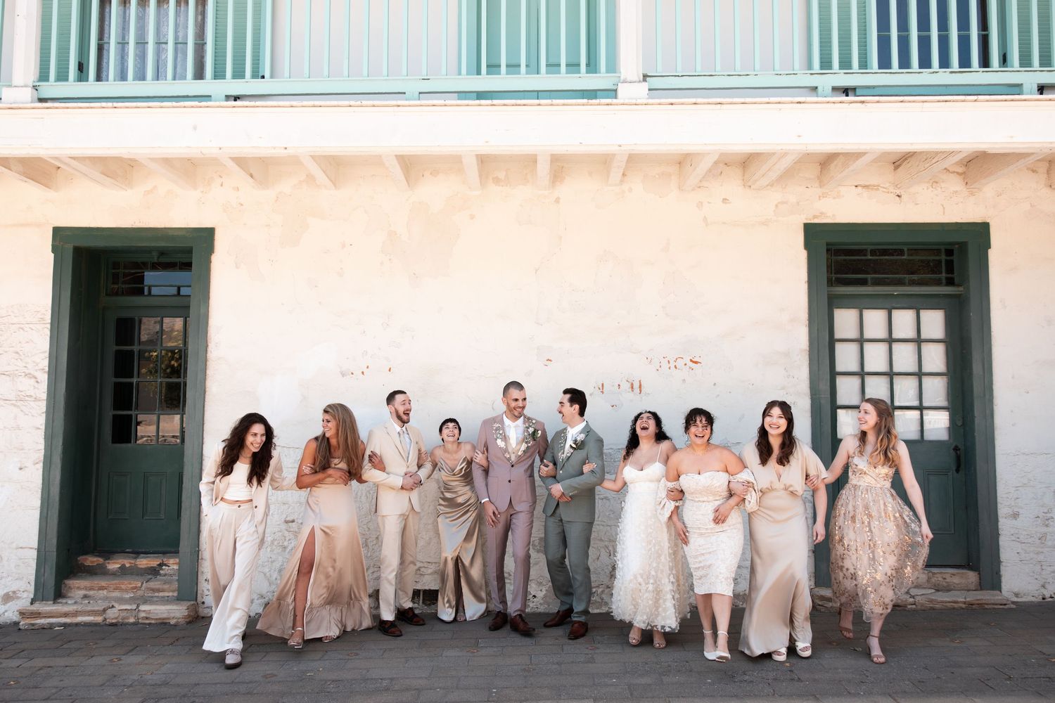 Wedding party members walk across a grassy field at sunset during an outdoor celebration ceremony.