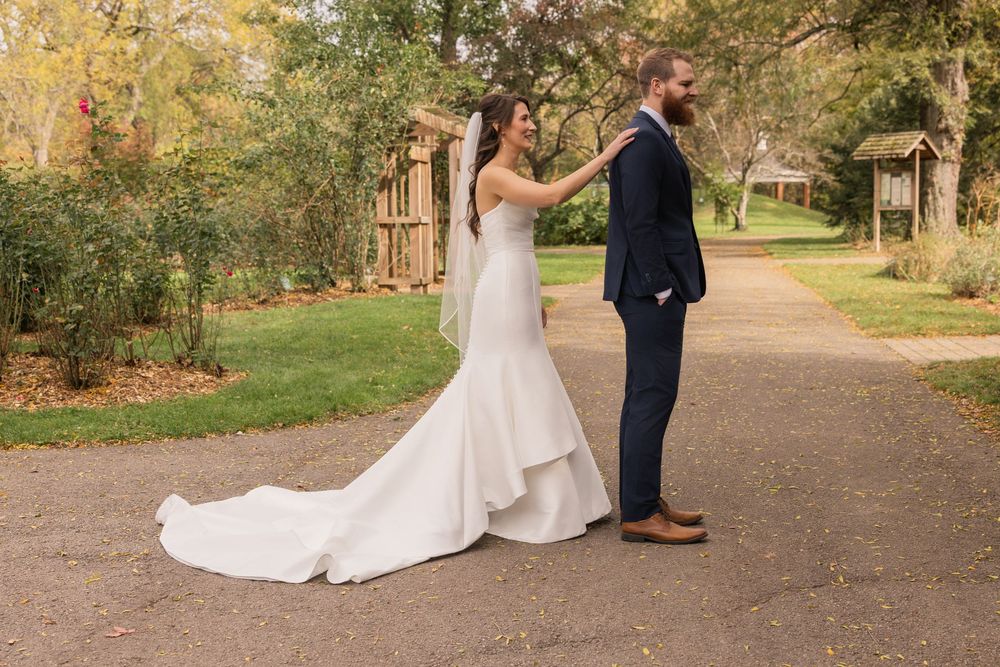 Romantic autumn wedding couple walking along a tree-lined path in a park setting. Park of roses wedding.