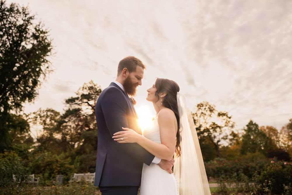 Romantic sunset wedding portraits with golden light filtering through trees. Park of roses Columbus