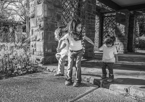 A sequence of black and white photos showing someone walking with a cane on a paved pathway. fort worth botanic gardens family session