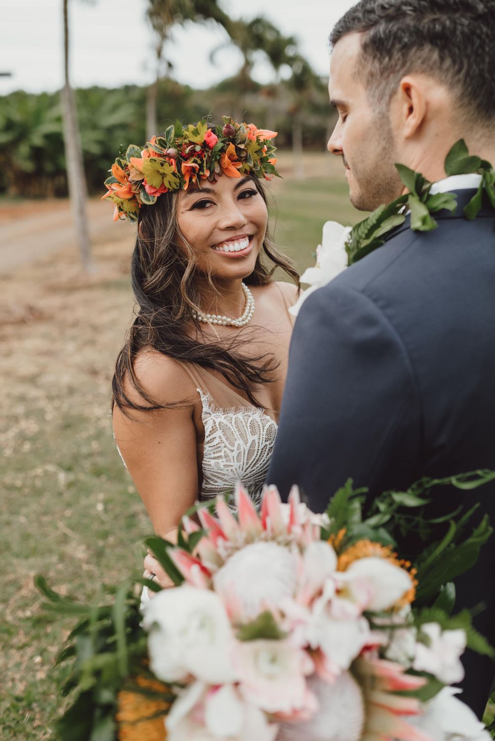 Romantic wedding moments with tropical flower crown and bouquet in outdoor setting.