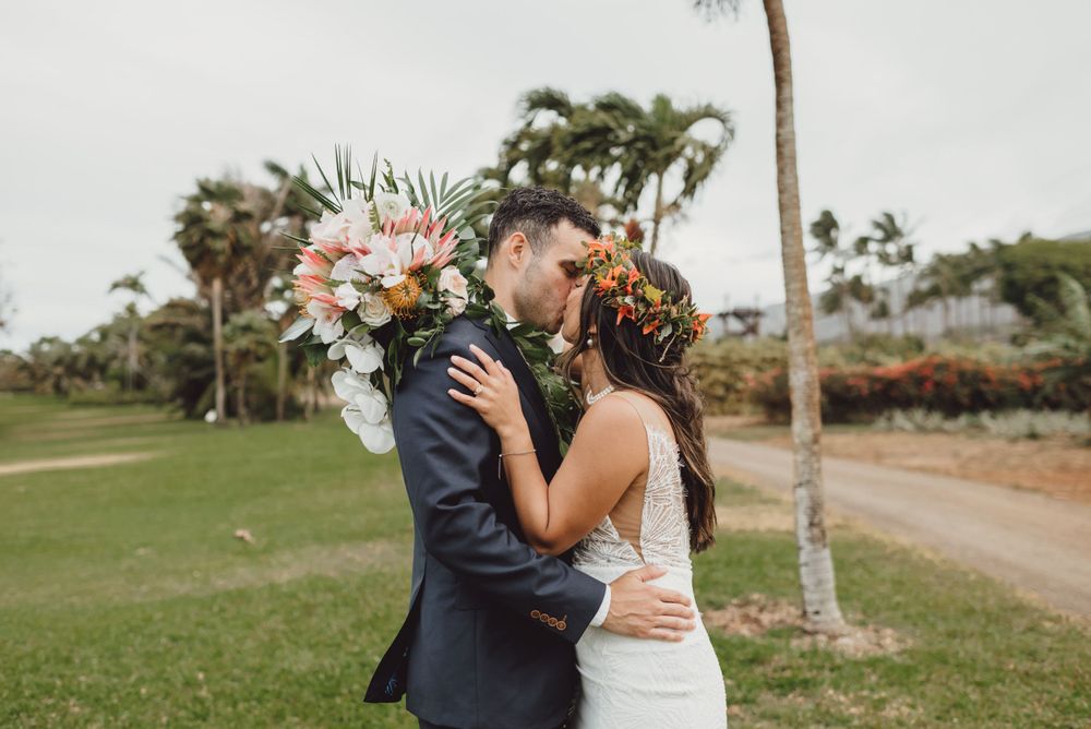 Wedding couple shares romantic moments in tropical garden landscape.