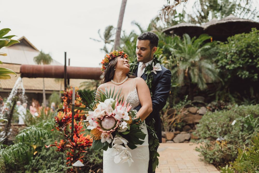 Wedding celebration with tropical floral arrangements in a garden setting.