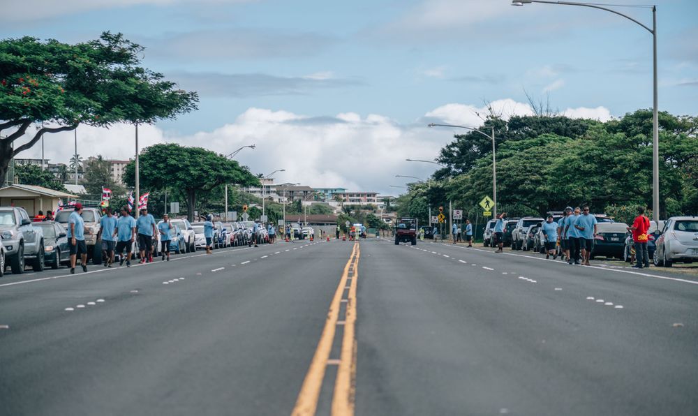 Empty street with road markings and palm trees visible in Hawaii.
