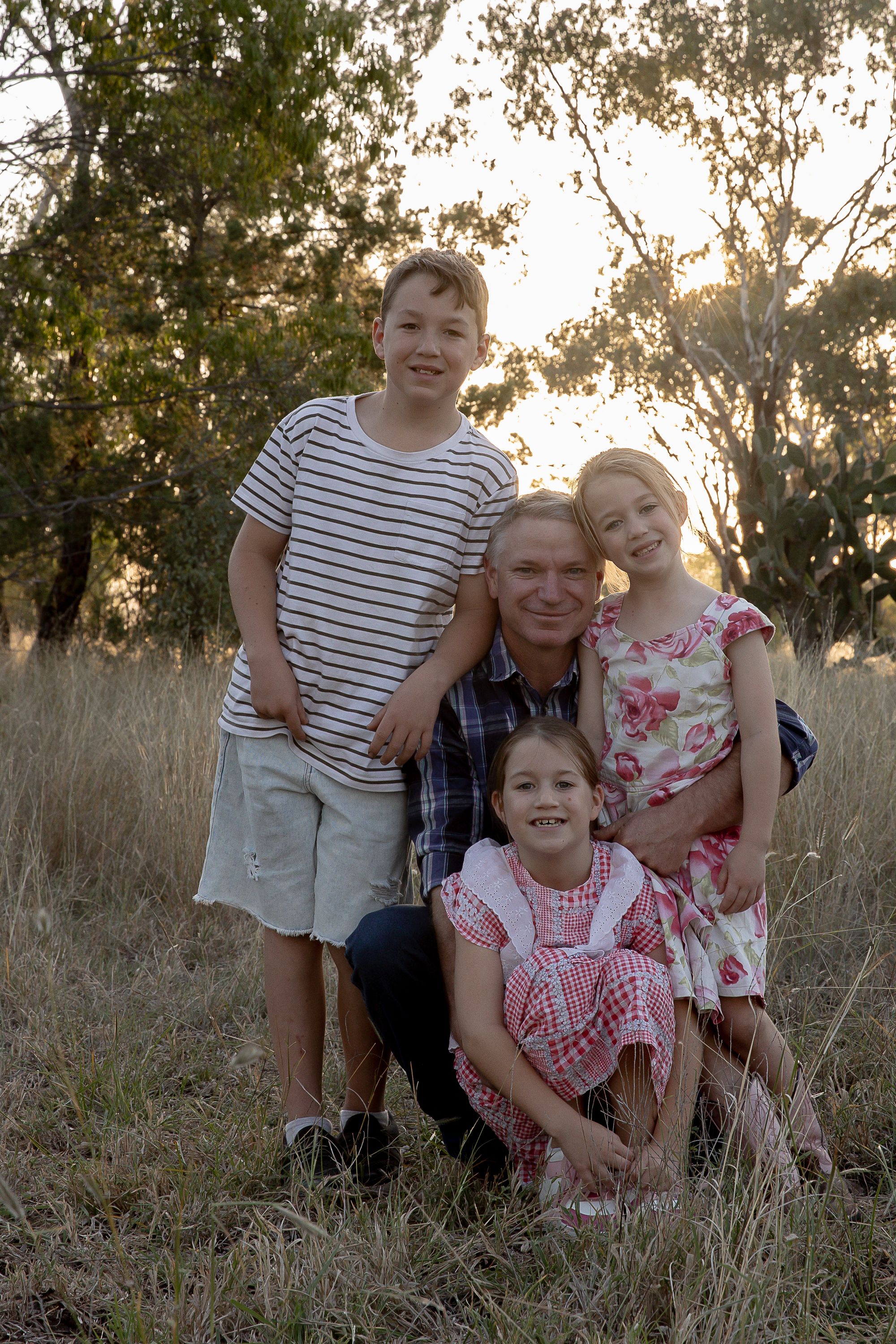 Family in a paddock at sunset during a professional family photo shoot