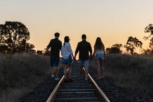family walking down the railway track at family professional photo shoot at sunset